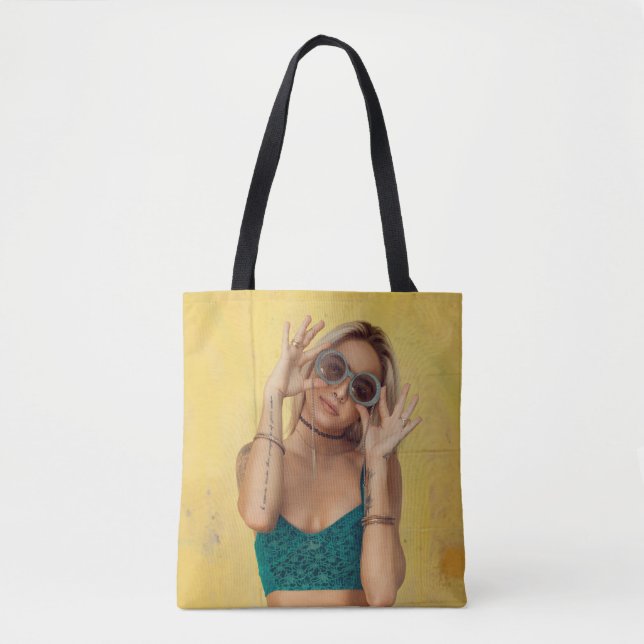 Woman in blue bralette holding sunglasses putting  tote bag (Front)