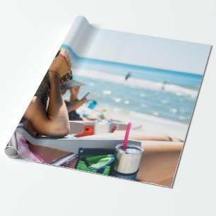 Woman lying on sun lounger covering her face with  wrapping paper