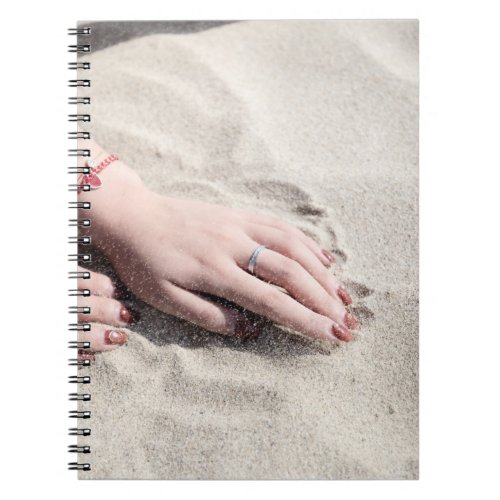 Woman lying on white sand notebook