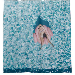 Woman on pink buoy surrounded by body of water in shower curtain