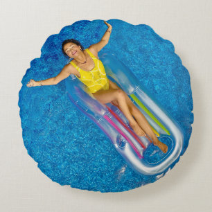 Woman riding on plastic floating buoy on body of w round pillow