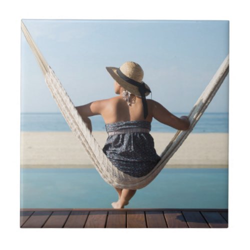 Woman Sitting On A Hammock At A Small Hotel Tile