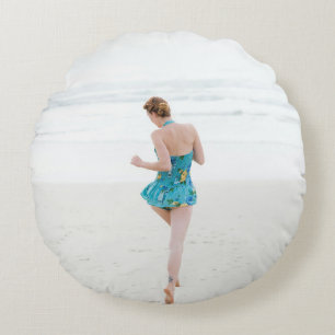 Woman walking on shore near beach round pillow
