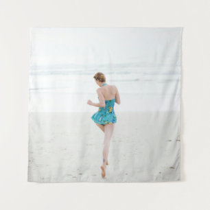 Woman walking on shore near beach tapestry