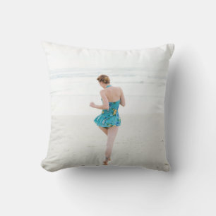 Woman walking on shore near beach throw pillow