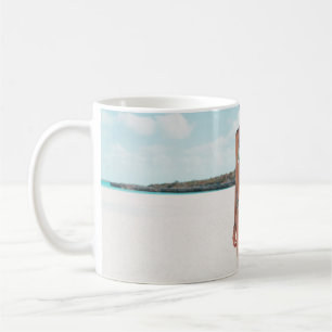 Woman wearing bikini standing on sand coffee mug