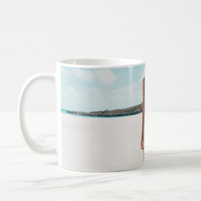 Woman wearing bikini standing on sand coffee mug (Left)