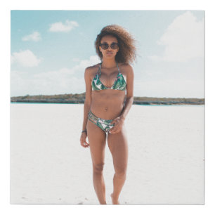 Woman wearing bikini standing on sand faux canvas print
