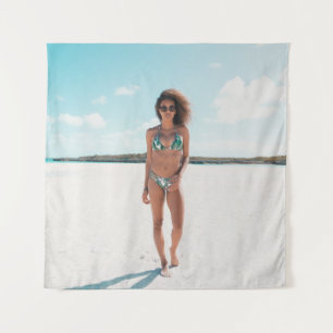 Woman wearing bikini standing on sand tapestry