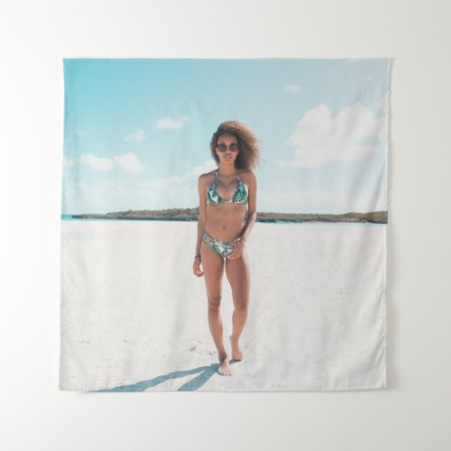 Woman wearing bikini standing on sand tapestry