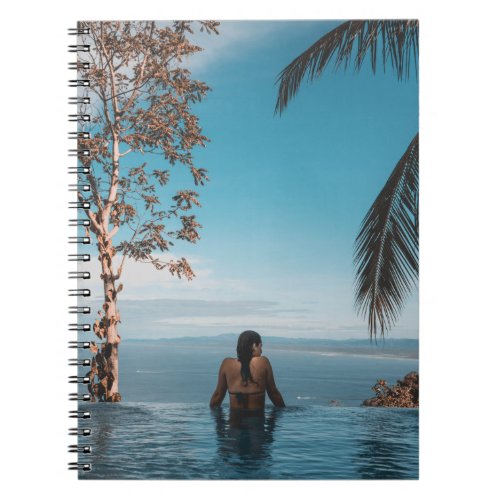 Woman wearing black bikini tap swimming on body of notebook