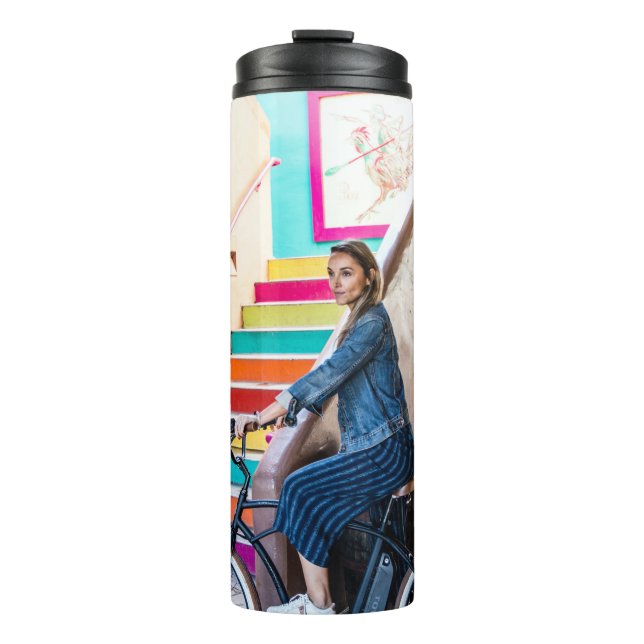 Woman wearing blue denim jacket and shorts riding  thermal tumbler (Front)