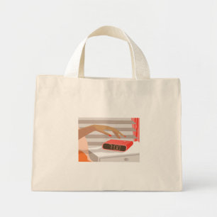 Womans hand pushing on alarm clock snooze button mini tote bag