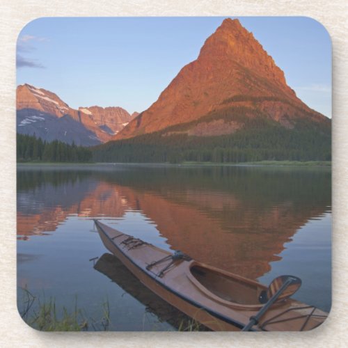 Wooden kayak in Swiftcurrent Lake at sunrise in Coaster