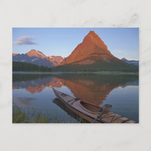 Wooden kayak in Swiftcurrent Lake at sunrise in Postcard