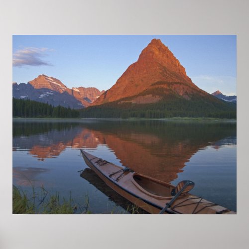 Wooden kayak in Swiftcurrent Lake at sunrise in Poster