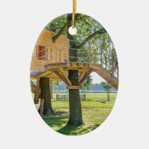 Wooden tree house in oak tree with grass ceramic ornament