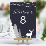 Woodland Deer Navy Table Number<br><div class="desc">Guide your guests to their seats with a touch of wintery elegance. These table numbers, featuring a majestic deer amidst a snowy woodland, add a touch of rustic charm to your reception. The navy blue border complements the natural scene, creating a sophisticated touch. Each table number is fully customizable, allowing...</div>