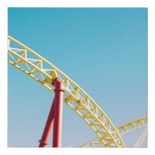 Yellow and red roller coaster under blue sky at da faux canvas print