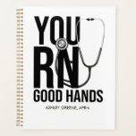 You RN Good Hands Planner<br><div class="desc">This notebook is designed especially for nurses, combining practicality with a personal touch. Whether you’re jotting down important patient notes, organizing your shifts, or simply keeping track of your thoughts during busy days, this notebook becomes your trusted companion. With customizable covers that allow you to add your name, title, or...</div>
