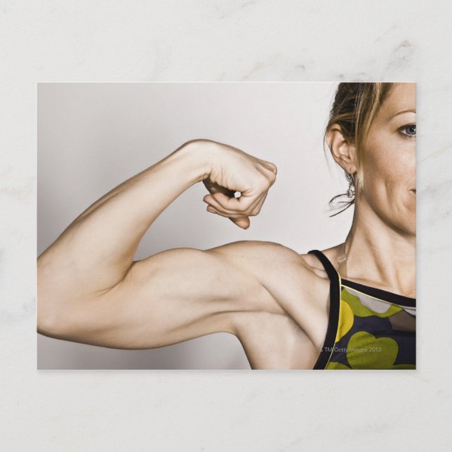 Young blond female flexes bicep muscle while postcard (Front)