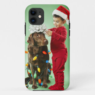 Young boy wrapping Christmas lights around a dog iPhone 11 Case