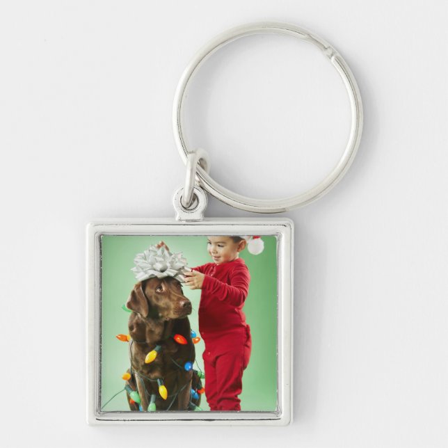 Young boy wrapping Christmas lights around a dog Keychain (Front)