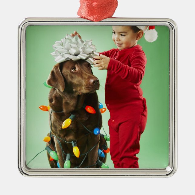 Young boy wrapping Christmas lights around a dog Metal Ornament (Front)