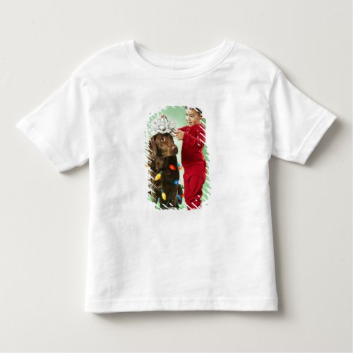 Young boy wrapping Christmas lights around a dog Toddler T_shirt