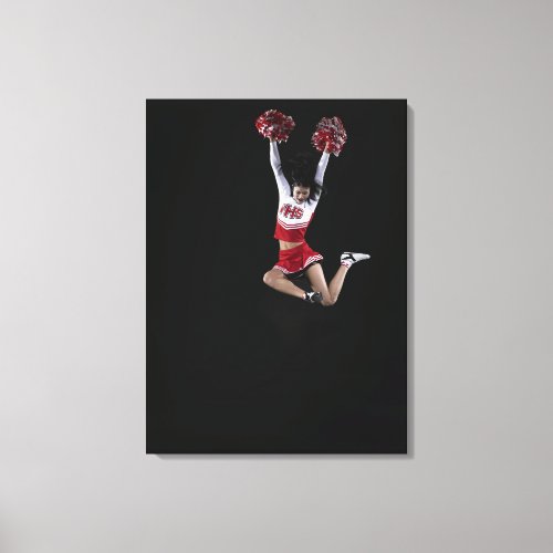 Young female cheerleader jumping in midair arms 2 canvas print