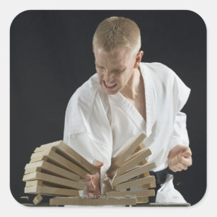 Young man breaking boards with karate chop on square sticker