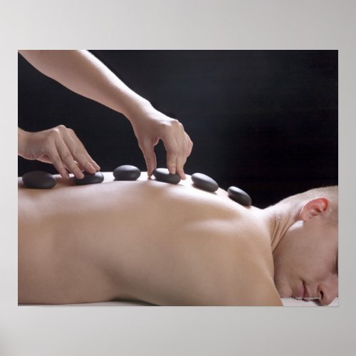 young man getting hot stone massage treatment poster