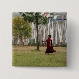 Young monk and prayer flags button