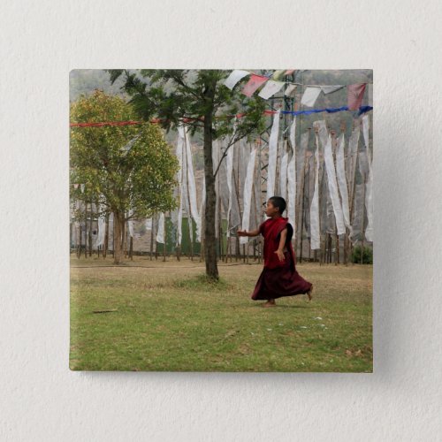 Young monk and prayer flags button