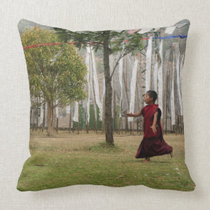 Young monk and prayer flags throw pillow
