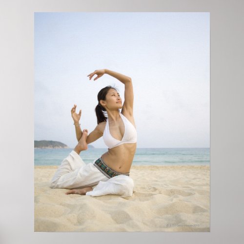 Young woman doing yoga on the beach poster